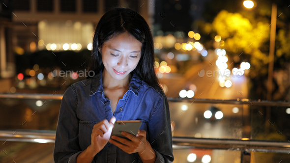 Woman using cellphone at night