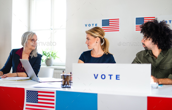 Members of electoral commission talking in polling place, usa elections