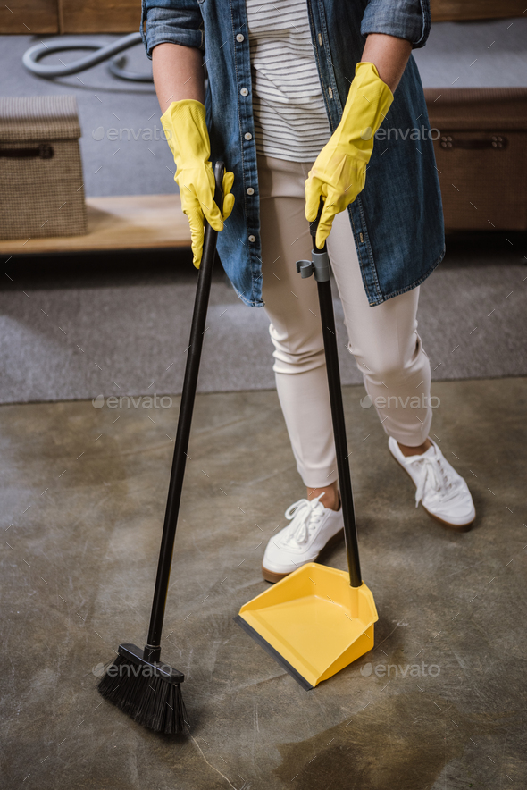 Premium AI Image  Two women wearing yellow uniforms with a broom and  gloves holding a dustpan.