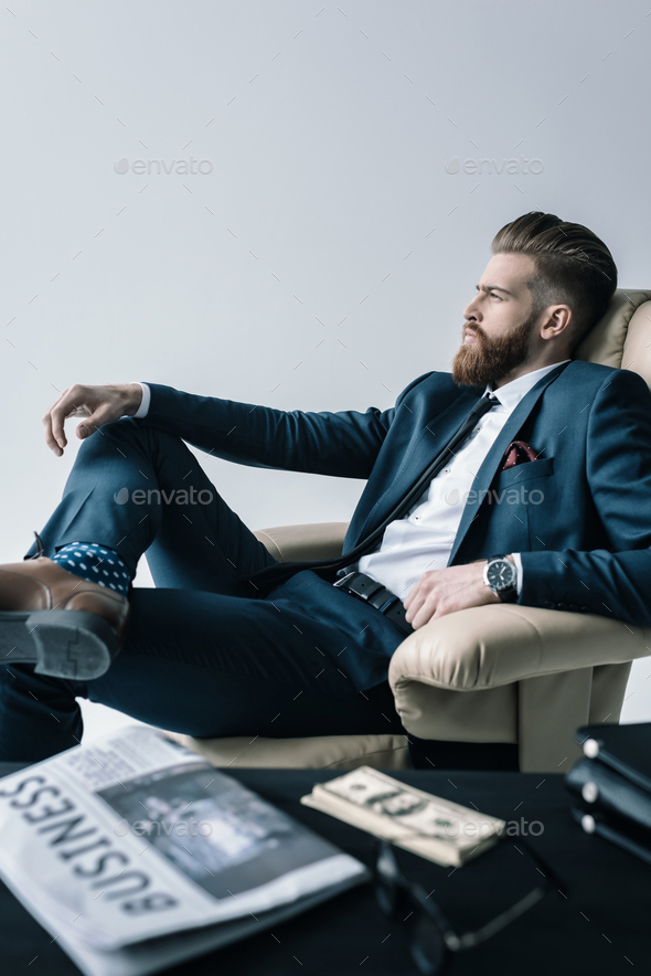 Side View Of Pensive Businessman Sitting In Armchair In Office Isolated On Grey Stock Photo By Lightfieldstudios