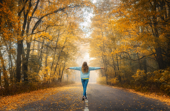 Young Woman On The Road In Autumn Forest At Sunset Stock Photo By Den Belitsky