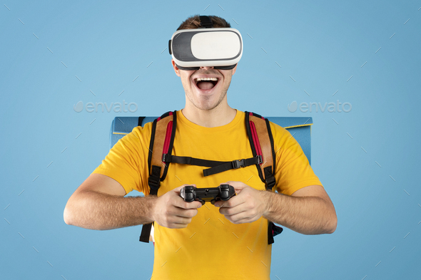 Virtual tourism. Excited guy with VR headset and controller watching travel tour in cyberspace on