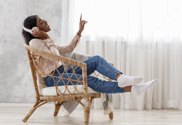 Joyful African Woman Singing While Listening Music With Wireless Headphones At Home - Stock Photo - Images