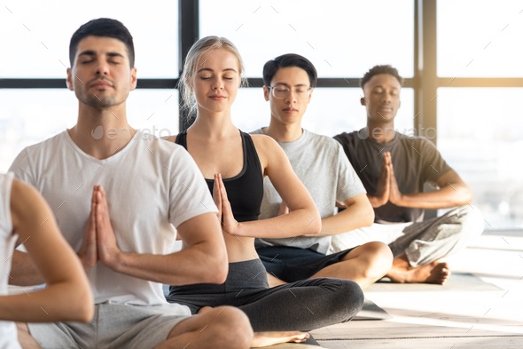 Meditation Exercise. Sporty Young People Practicing Yoga During Group  Lesson In Studio Stock Photo by Prostock-studio