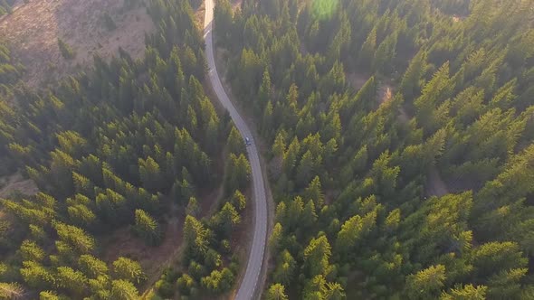Car driving along the mountain forest road. Aerial view alt