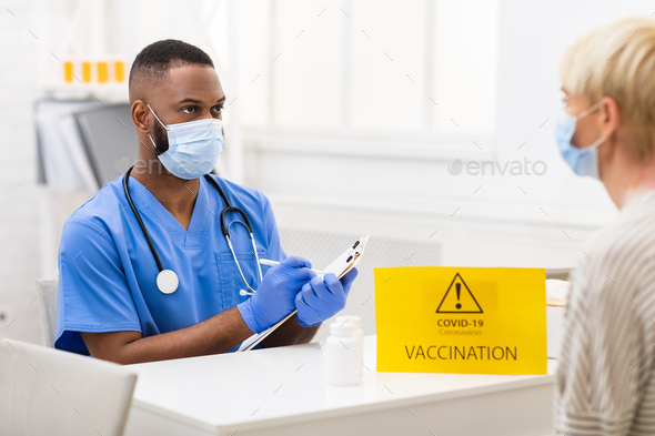 Doctor Talking With Patient During Appointment For Covid-19 Vaccination Indoor - Stock Photo - Images