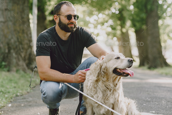 Blind man with guide dog in a summer city