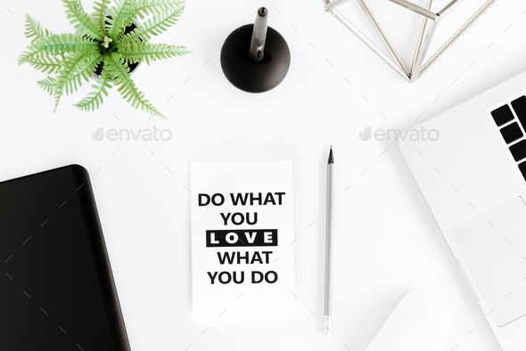 Top view of do what you love, love what you do motivational quote and laptop at workplace