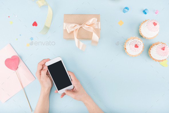 Download Top View Of Human Hands Holding Smartphone With Cakes And Gift Box Mock Up Birthday Party Stock Photo By Lightfieldstudios