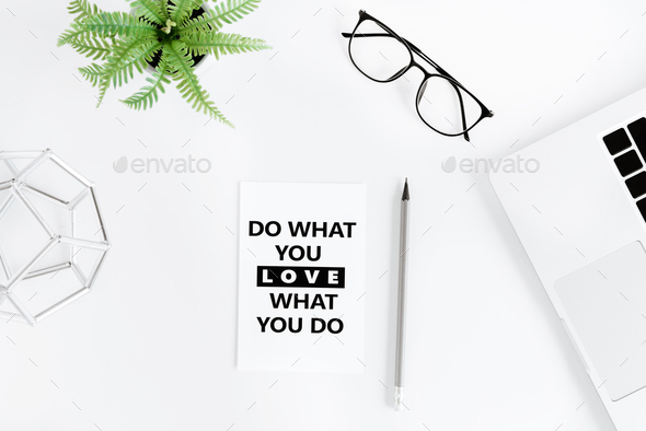 flat lay with Do what you love and love what you do motivational quote on modern workplace with