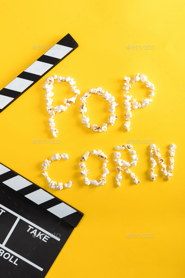 Pop corn lettering made from popcorn and movie clapper on yellow, Movie time concept