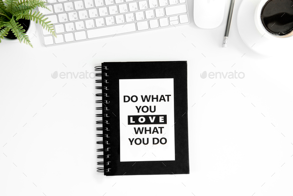 flat lay with do what you love what you do motivational quote on diary, computer mouse and keyboard