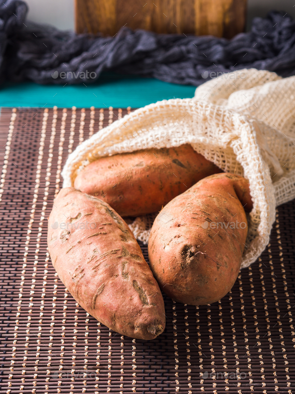 Sweet potato in a reusable cotton mesh bag - Stock Photo - Images