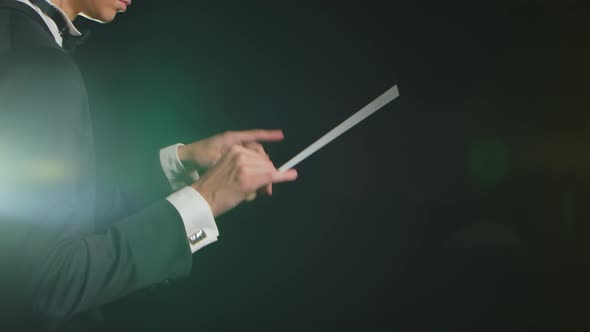 Symphony Orchestra Conductor Wearing Suit is Directing Musicians with