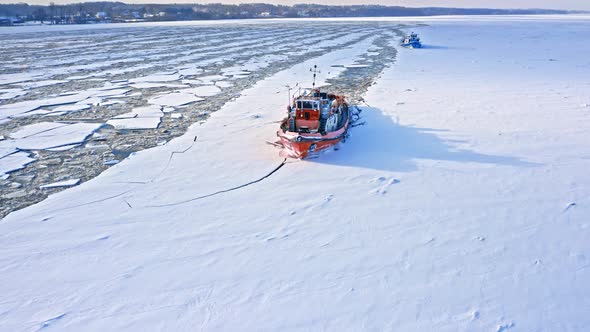 Icebreakers on Vistula river breaking ice. Aerial view of winter. alt