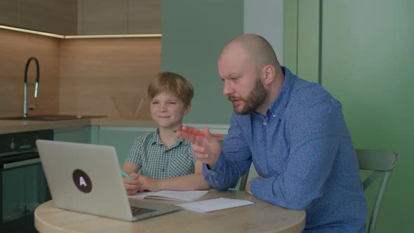 Father Helping His Son with Online Homework alt