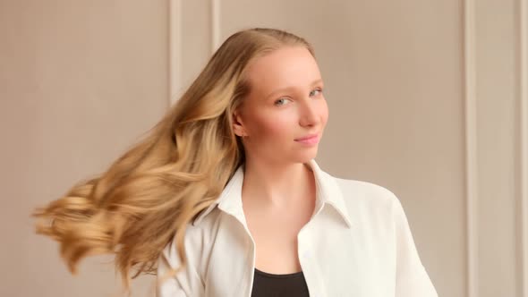 Young blonde woman lets long hair down takes the hair clip off and does hair style alt
