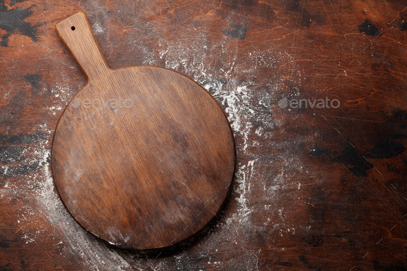 Empty wooden cutting board on a kitchen table. Top view, copy