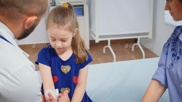 Doctor bandaging child hand - Stock Photo - Images