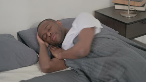 African Man Sleeping in Bed Peacefully alt