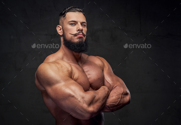 Bodybuilder with beard posing with crossed arms in studio Stock Photo by  fxquadro