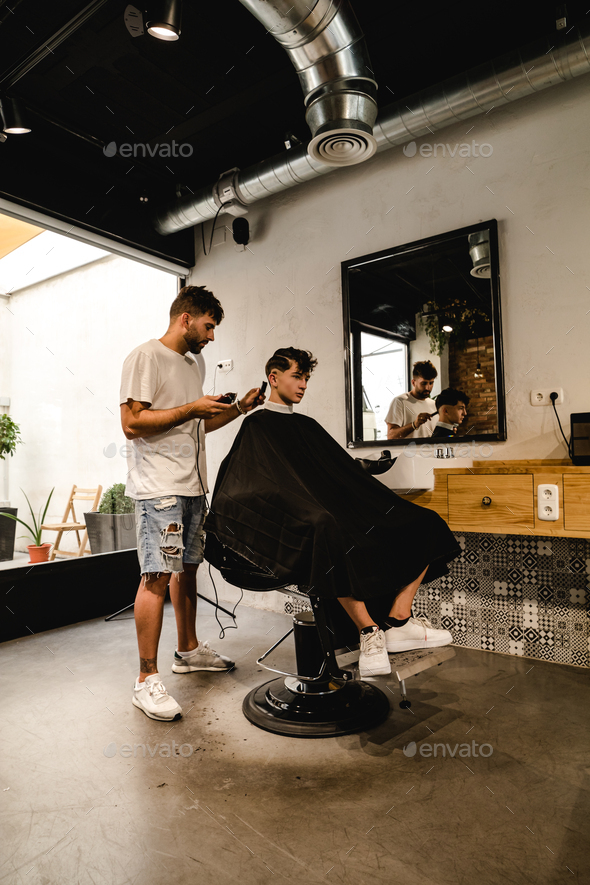Men Hair Salon. Barber Doing Haircut In Barbershop. Young Male Client And  Hairdresser. Stock Photo by MegiasD