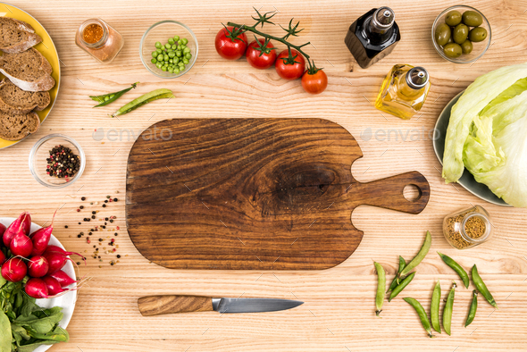 Fresh vegetables on woden cutting board with knife