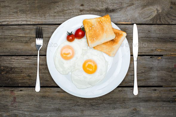 top view of fresh tasty breakfast with fried eggs and toasts on plate - Stock Photo - Images