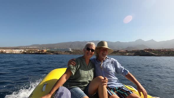 Beautiful and cute couple of seniors or old people in the middle of the sea driving and discovering