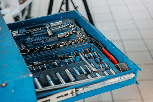 An open shelf filled with car repair tools in a service workshop.