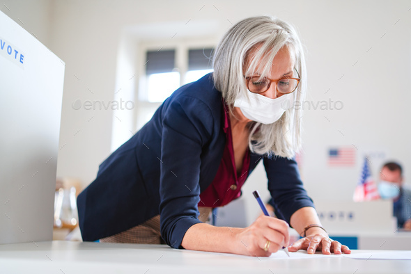 Portrait of woman voter with face mask in polling place, elections and coronavirus concept
