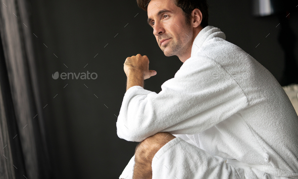Handsome young man in bathrobe relaxing at spa wellness hotel