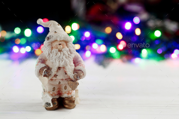 christmas santa claus toy on background of colorful garland lights - Stock Photo - Images