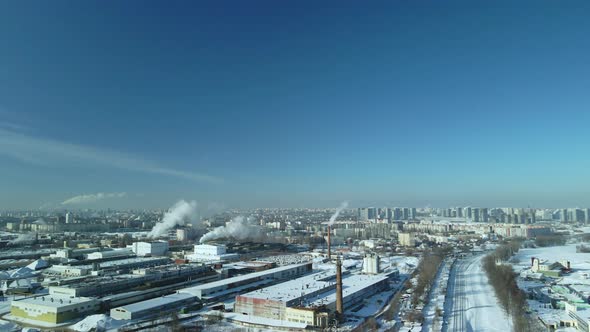 Factory Buildings Covered With Snow. Factory Smoke Chimneys. alt