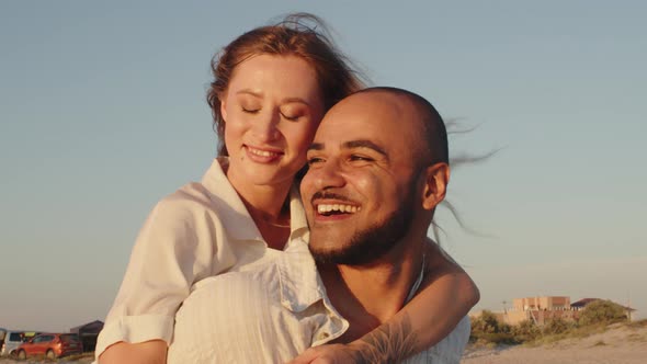 Young Beautiful Couple in Love Standing and Hugging on Beach By the Sea