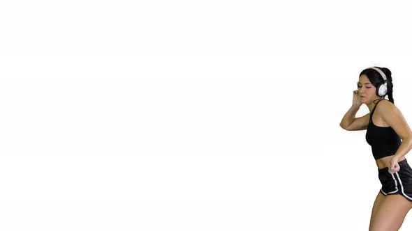 Young Happy Sportive Woman Dancing and Listening To Music in Headphones on White Background. alt