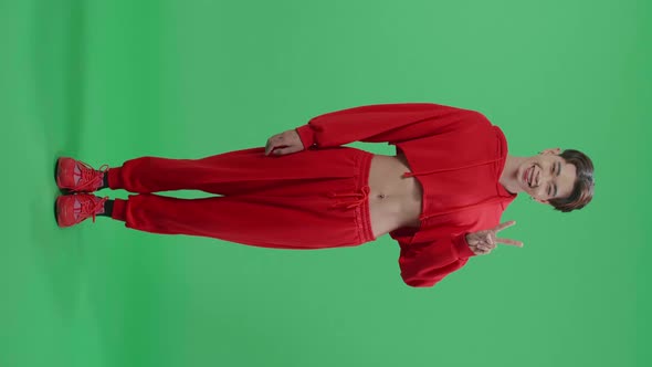 Full Body Of A Smiling Young Asian Transgender Male Showing Gesture Peace In Green Screen Studio alt
