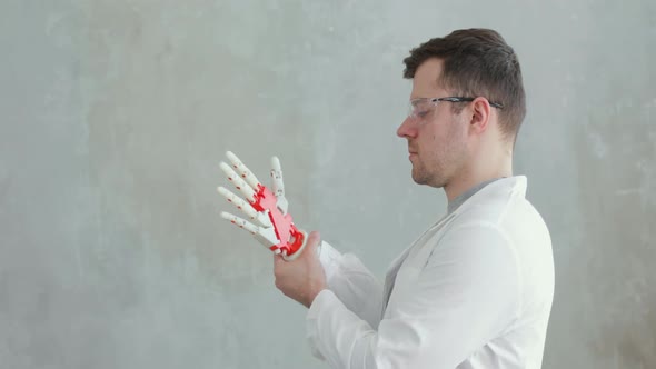 Portrait of Scientist Engineer Conducts Tests of Robotic Prosthetic Hand Trying To Move Fingers alt