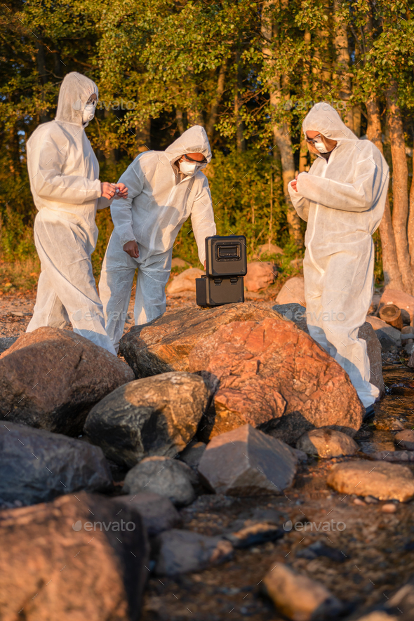 Researchers in team with container at beach taking water samples - Stock Photo - Images