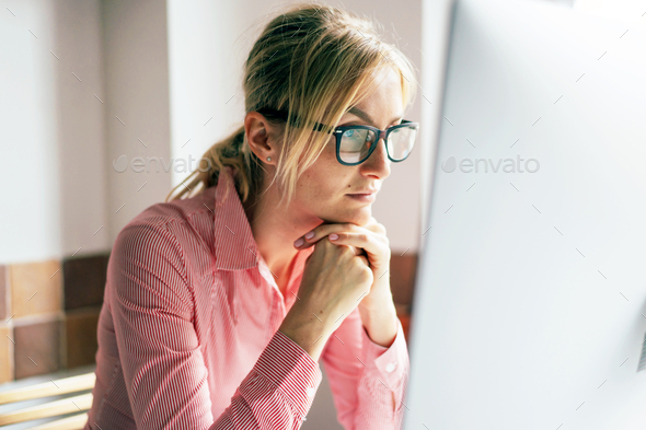 Business woman in glasses looks at the computer monitor. Home office. Remote work. - Stock Photo - Images