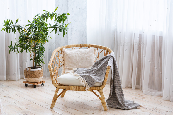 Interior of cozy modern house. Armchair with blanket on wooden