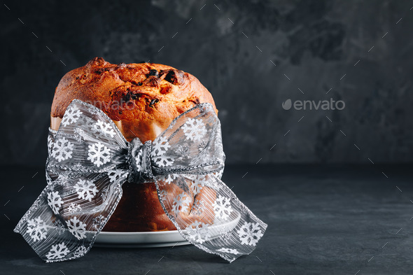 Panettone cake. Traditional Italian Christmas cake with dried fruits on dark stone background - Stock Photo - Images