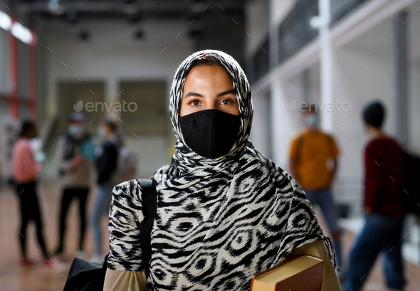 Islamic student with face mask back at college or university, coronavirus concept.