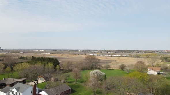 rural landscape in autumn with farm land, homes, train tracks and community in the scene.