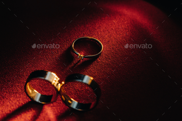 Two Wedding Rings And One Engagement Ring On A Red Background Three Gold Rings Of A Couple In Love Stock Photo By Lobachad