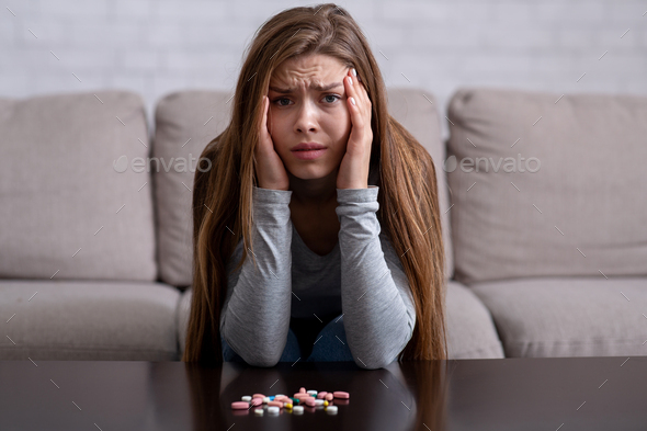 Emotional breakdown and suicide. Young lady with pills having psychological disorder and planning to