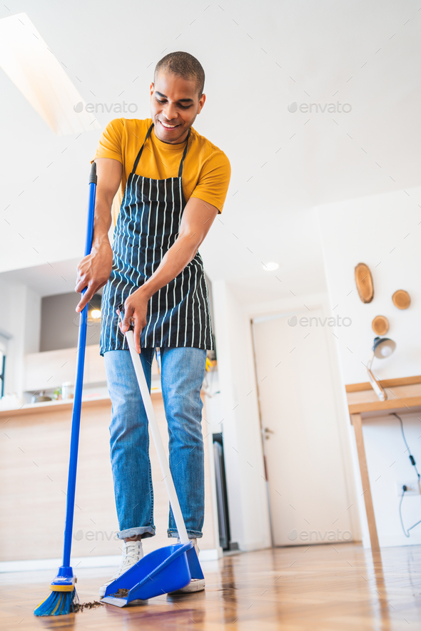 House cleaning. House cleaning man. House man sweeping and mopping