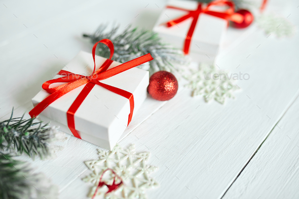 Christmas gift box, fir tree branches, red decorations on white wooden background, Christmas, winter, new year concept, Flat lay, top view, copy space