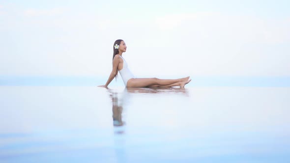 Young asian woman enjoy around outdoor swimming pool for leisure alt