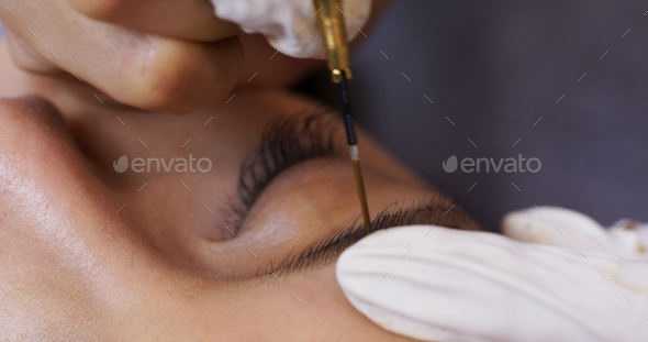Beautician specialist of permanent makeup making brow microblading tattooing make up
